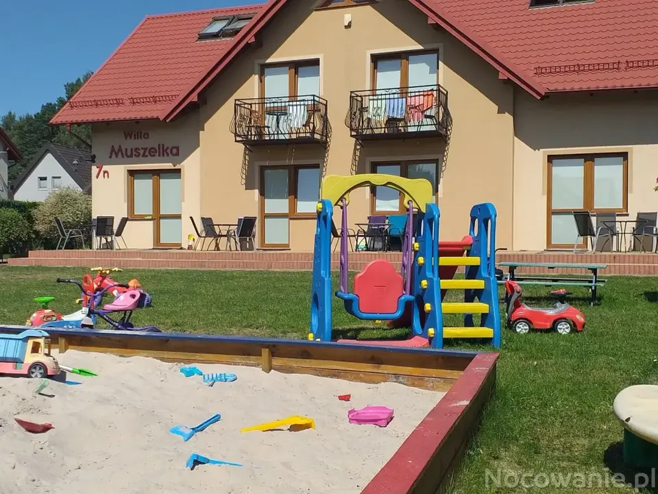 Plac zabaw dla dzieci z piaskownicą i zjeżdżalnią przed Willą Muszelka w Dębkach