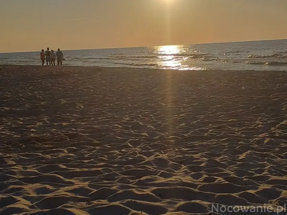 Zachód słońca na plaży w Dębkach nad Morzem Bałtyckim — złoty piasek i morze